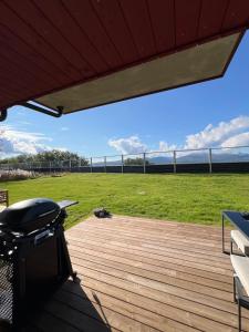 a deck with a grill and a grass field at Modern apartment with view in Lii