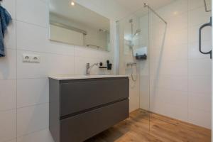 a bathroom with a sink and a shower at Moderne vakantie woning in Domburg +10 photos