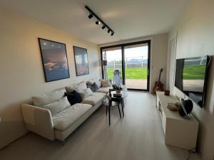 a living room with a white couch and a tv at Modern apartment with view in Lii +5 photos