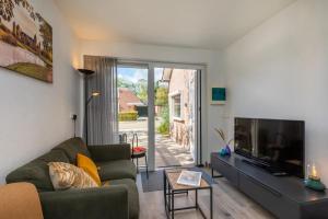 a living room with a couch and a tv at Moderne vakantie woning in Domburg