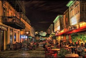 a group of people sitting at tables on a street at night at Bigapart sity centre, old Tbilisi in Tbilisi City +8 photos