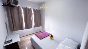 ゴイアニアにあるDom Victor Residence Hotel 2の紫色の毛布が掛けられたベッドのある小さな白い部屋 +12枚の写真