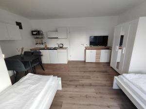 a white room with a kitchen and a dining table at ACR-Accommodations, Gästezimmer, Monteurunterkünfte in Öhringen