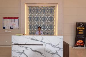 a man standing behind a counter in a room at Private Cinema Apartment By Buddies Home in Greater Noida +25 photos