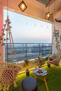 a room with swing chairs and a large window at Private Cinema Apartment By Buddies Home in Greater Noida