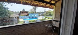 a balcony with a view of a swimming pool at Chalés Do Sol in Boracéia