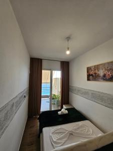 a bedroom with a bed in a room with a window at Rafa's Apartament in Himare