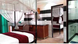 a bedroom with a bed and a bathroom with a mirror at Toque & GN Apartment in Nairobi