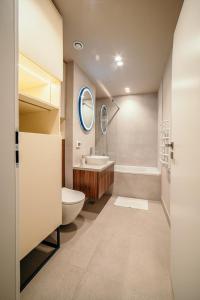 a bathroom with a toilet and a sink and a tub at Cazare Suceava Self Check-in şi Parcare Subterană in Suceava