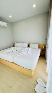 ein Schlafzimmer mit einem großen Bett mit weißer Bettwäsche in der Unterkunft Hill Jai Poolvilla Khao Kho in Khao Kho