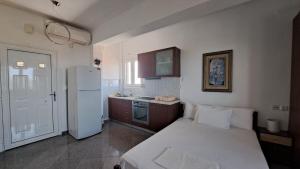 a kitchen with a bed and a white refrigerator at Daniel Studios in Kallithea Halkidikis +103 photos