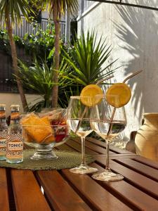 three wine glasses sitting on a wooden table with fruit at Etna Docet in Nicolosi +17 photos