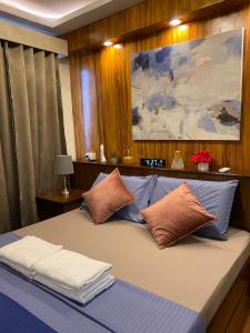 a bedroom with a large bed with pillows on it at Executive Suite Condo 1 in Dumaguete +16 photos