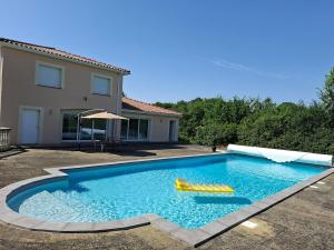 a swimming pool with a raft in a yard at Belvédère du bonheur in Samatan