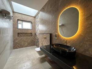 a bathroom with a black sink and a mirror at Red Apple Farm Villa by Mystic Hotels  +32 photos