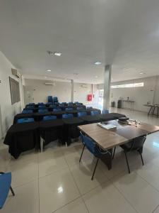 a large room with tables and blue chairs at Palace Hotel in Altamira