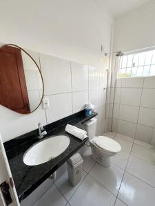 a bathroom with a sink and a toilet and a mirror at Lar de Maria Aguiar in Barreirinhas +6 photos