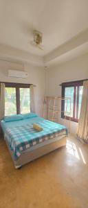 a bedroom with a bed in a room with windows at Secret Thai Peace No1 in Thongsala