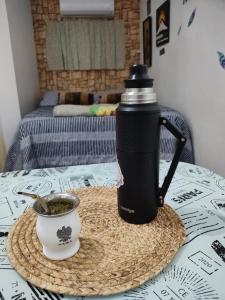 a water bottle and a cup of coffee on a table at BARDAS del LIMAY DORMI-con HIDROMASAJE - totalmente EQUIPADO in Plottier +11 photos