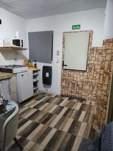 a room with a kitchen with a brick wall at BARDAS del LIMAY DORMI-con HIDROMASAJE - totalmente EQUIPADO in Plottier