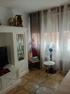 ein Wohnzimmer mit einem Tisch und einem Ventilator in der Unterkunft Piso, Bonito,Acogedor y Barato in Castellón de la Plana