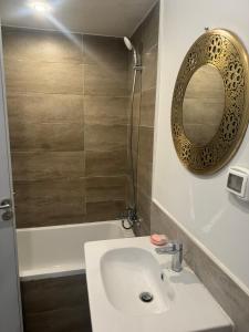 ein Badezimmer mit Waschbecken, Spiegel und Badewanne in der Unterkunft Cozy Garden Flat with Full Kitchen in Madīnat aţ Ţalāʼi‘