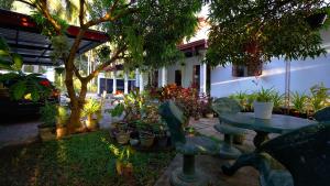 a garden with a table and chairs and plants at Sun Leaf Lake in Dambulla