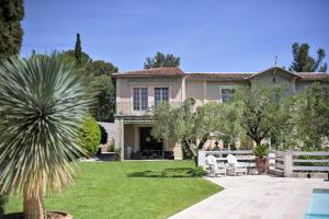 una casa con una palmera en el patio en Chambres d'hôtes - Nîmes - Villa des roses, en Nimes