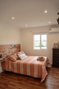 a bedroom with a bed and a window at Cabañas El Nono in Tandil