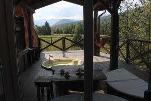 a bathroom with a tub and a balcony with a view at містечко Швейцарське in Dragonya +21 photos
