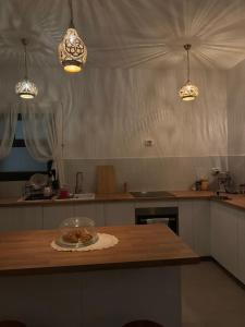 eine Küche mit einem Tisch mit einer Schüssel Essen drauf in der Unterkunft Cozy Garden Flat with Full Kitchen in Madīnat aţ Ţalāʼi‘ + 6 Fotos