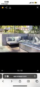 a tv screen with a couch and a bench at Janna hospitality in San Diego