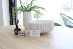 Un jarrón blanco sobre una mesa con dos notas adhesivas. en LuxApart74 l Comfy & Minimal Stay in Ierapetra, en Ierápetra