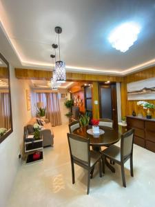 a dining room and living room with a table and chairs at Executive Suite Condo 1 in Dumaguete