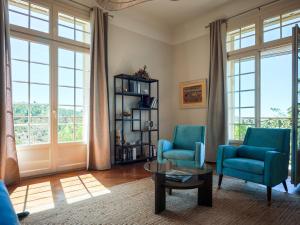 Una sala de estar con dos sillas azules y una mesa. en Chambres d'hôtes - Nîmes - Villa des roses, en Nimes