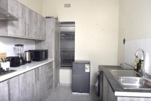 a kitchen with a sink and a refrigerator in it at Private Guest suite in Ferndale in Johannesburg
