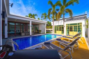 a house with a swimming pool and a villa at Beautiful 4-Bedroom Pool Villa - BL9 in Hua Hin