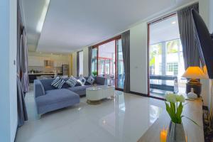 a living room with a blue couch and a table at Beautiful 4-Bedroom Pool Villa - BL9 in Hua Hin