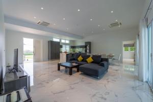 a living room with a couch and a table at Nice 3BR with Golf Course View - BMG3 in Hua Hin