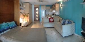 sala de estar con cama y sofá en Cozy Beachfront Studio en San Juan