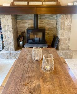 PenneにあるMaison gorges de l'Aveyronの暖炉のある木製のテーブルと3つのバスケット