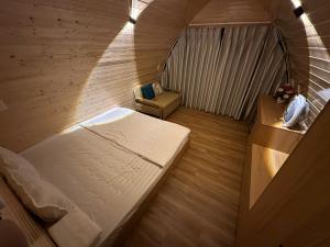 een kleine kamer met een bed en een stoel bij Bình An Mountain Side Bungalow in Nguyên Ngoại +20 foto's