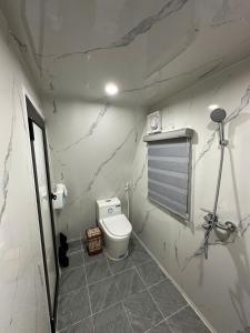 een badkamer met een toilet en een marmeren muur bij Bình An Mountain Side Bungalow in Nguyên Ngoại