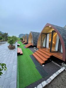 een rij lodges met banken en gras bij Bình An Mountain Side Bungalow in Nguyên Ngoại