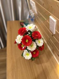 een boeket rode en witte bloemen op een tafel bij Bình An Mountain Side Bungalow in Nguyên Ngoại