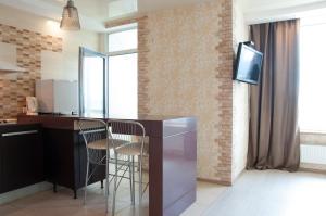 a kitchen with a counter and a tv in a room at Apartment on Bogatyrskaya 6a in Kyiv