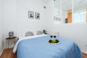 a bed with a plate of grapes and two glasses of wine at Lumina Charming 3-room apartment in the center of Warsaw in Warsaw +17 photos