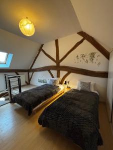 deux lits dans une chambre avec un toit dans l'établissement Le terroir des sens, à Corgengoux 35 autres photos