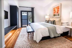 a bedroom with a large bed and a chair at Olsen Penthouse - Art House Townhouses in Bright