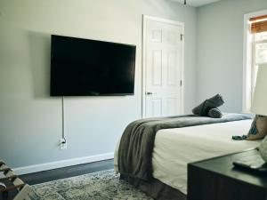 a bedroom with a bed and a flat screen tv on the wall at Visit Chill House 15 miles from Windham Hot Tub and Ping Pong in Cairo